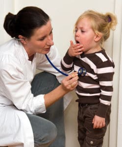 Kleines Mädchen mit Husten wird von Ärztin untersucht