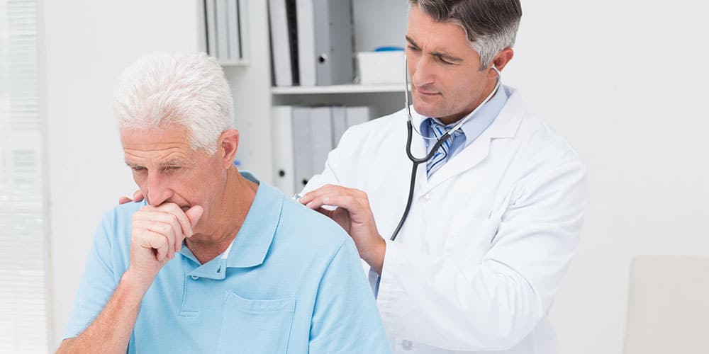 Älterer Mann mit Chronischer Bronchitis wird von Arzt untersucht
