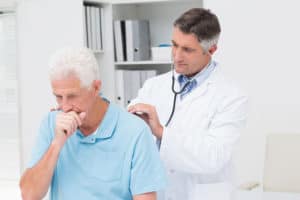 Mann mit chronischer Bronchitis wird vom Arzt untersucht